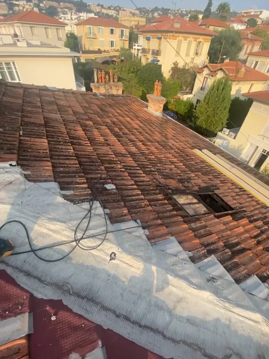 Faîtage repris sur une toiture de village, chantier de charpente et de couverture