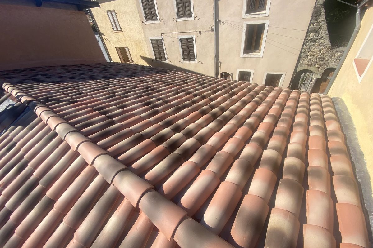 Toiture de maison de village reprise par RF Toiture, accès étroit entre deux façades